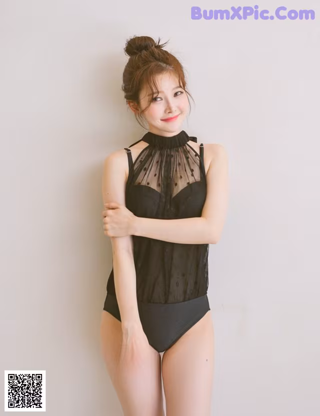 A woman in a black bathing suit posing for a picture.