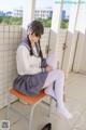 A woman in a school uniform sitting on a chair.