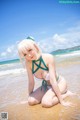 A woman in a bikini sitting on the beach.