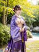 A woman in a purple kimono posing for the camera.