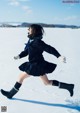 A woman in a school uniform is running in the snow.