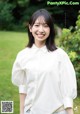 A woman in a white shirt smiles at the camera.