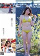 A woman in a yellow bikini standing next to a bush of sunflowers.