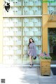 A woman standing in front of a building with a cat on it.