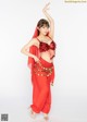 A woman in a red belly dance outfit posing for a picture.