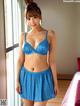 A woman in a blue bra and skirt posing for a picture.