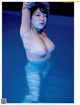 A naked woman standing in a pool of water.